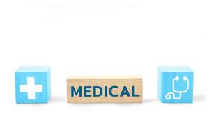 hölzern Block mit das Wort medizinisch und medizinisch Symbole. Gesundheit Pflege, Gesundheit Versicherung und Behandlung Konzept. foto