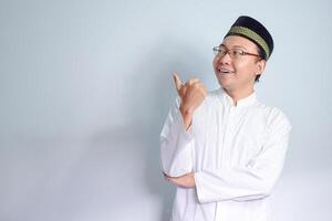 asiatisch Muslim Mann tragen Brille und Weiß Stoff lächelnd und zeigen Pose zum Ramadhan und eid al fitr. isoliert Weiß Hintergrund foto