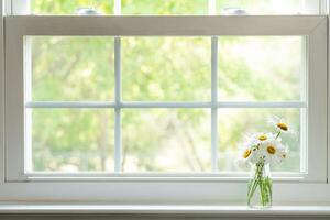 Gänseblümchen Strauß im klein klar Glas Vase auf Weiß Fensterbrett foto