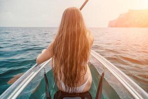 Frau im Kajak zurück Sicht. glücklich jung Frau mit lange Haar schwebend im transparent Kajak auf das Kristall klar Meer. Sommer- Urlaub Ferien und heiter weiblich Menschen entspannend haben Spaß auf das Boot foto