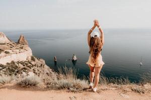 Frau Reise Meer. glücklich Tourist nehmen Bild draußen zum Erinnerungen. Frau Reisender sieht aus beim das Kante von das Cliff auf das Meer Bucht von Berge, Teilen Reise Abenteuer Reise foto