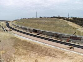 Berg Straße Kontraktion. Arbeitskräfte verstärken das Steigung Über das Neu Straße. Straße Konstruktion im Fortschritt auf Steigung Natur Schlucht. Infrastruktur Entwicklung und Logistik. Antenne Drohne Schuss foto