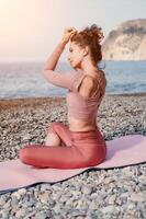 Mitte alt Gut suchen Frau mit schwarz Haar, Fitness Lehrer im Gamaschen und Spitzen tun Dehnen und Pilates auf Yoga Matte in der Nähe von das Meer. weiblich Fitness Yoga Routine Konzept. gesund Lebensstil foto