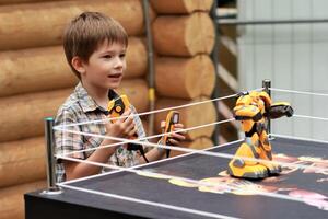 Junge spielen Schlacht Kampf Roboter mit Fernbedienung Steuerung draußen foto