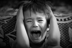 schwarz und Weiß Porträt von ein Junge Weinen aus laut foto