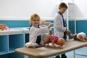 Kinder Lernen zu machen Injektionen zu Baby Puppen, Gesundheit Pflege Konzept foto