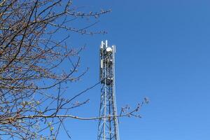 elektrische antenne und kommunikationssender turm in einer nordeuropäischen landschaft vor blauem himmel foto
