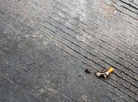 die Zigarettenkippe auf den Betonboden fallen lassen foto
