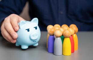 ein Geschäftsmann hält ein Blau Schweinchen Bank Nächster zu ein Gruppe von Menschen Zahlen. erziehen Budget Mittel. gut Anzahlung Bedingungen. Neu profitabel bietet an mit Renten und Ersparnisse Systeme. Finanzierung foto