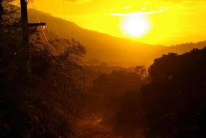 Sonnenlicht des Sonnenuntergangs und eine unbefestigte Straße auf dem Land foto