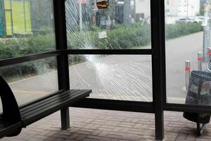 gebrochen Glas beim das Bus stoppen. Öffentlichkeit Transport Bahnhof zerstört durch das Glas Fenster. Risse von temperiert Glas foto