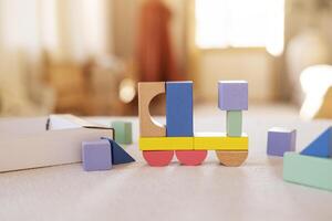 bunt hölzern Blöcke auf Zuhause Tisch. Kreativität Spielzeuge. Kinder Gebäude Blöcke. geometrisch Formen - - Kreis, Dreieck, Quadrat, Rechteck. logisch Denken. foto
