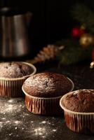 Schokolade Muffins mit pulverisiert Zucker auf oben auf ein schwarz Hintergrund. Weihnachten Dekoration . immer noch Leben schließen hoch. Essen Foto. foto