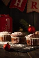 Schokolade Muffins mit pulverisiert Zucker auf oben auf ein schwarz Hintergrund. Weihnachten Dekoration . immer noch Leben schließen hoch. Essen Foto. foto