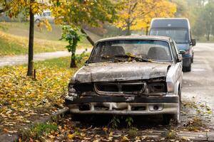 ein gebrochen Nieder verlassen alt Auto in der Nähe von Straße foto