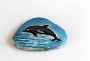Meer Stein Kieselsteine mit ein gemalt Delfin. Souvenir. foto