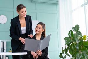 jung Frauen Führer sind Überprüfung finanziell Aussagen von Papier Unterlagen. zwei weiblich zuversichtlich Geschäft Arbeiter gekleidet schwarz passen im Büro Überprüfung finanziell dokumentieren foto