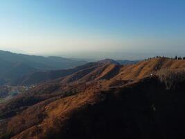 Antenne Aussicht von Berg Plateau und Klippen. Herbst Foto von Hohe Höhe Landschaft mit Bäume. Landschaft beim Sonnenuntergang im schön Natur im das Herbst Jahreszeit. orange, Blau, Gold Farben