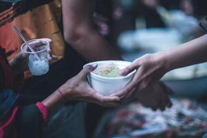 das Konzept von humanitär Hilfe Teilen Essen zu das Arm foto