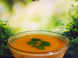 Orange Saft im Bar Glas im Vorderseite von Blätter Herz Form- Obst trinken im das Glas - - Cocktail foto