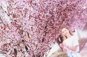 Mädchen unter schön Kirsche Blüten im voll blühen foto