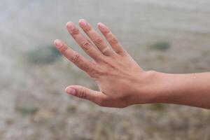 Hand ohne Engagement Ring mit Sonnenbräune. das Mädchen dauerte aus das Hochzeit Ring auf Ferien Das Nein einer wusste Das sie war verheiratet foto