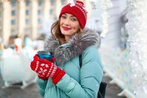 schön schön mittleren Alters Mädchen mit lockig Haar warm Winter Jacken steht Hintergrund Stadt, Dorf Quadrat. foto