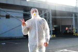 covid-19 Coronavirus Arzt Stehen Krankenhaus Parkplatz gekleidet Weiß schützend Overall Hazmat Anzug. foto