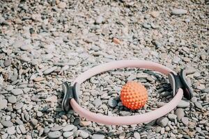 Pilates Magie Ring und Gummi Band auf Yoga Matte in der Nähe von Meer. weiblich Fitness Yoga Konzept. gesund Lebensstil Harmonie und Meditation. foto