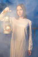 mysteriös mystisch Mädchen im ein dunkel Nacht Wald mit ein Kerosin Lampe im ihr Hände foto