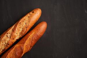 zwei knusprig Französisch Baguettes Lüge auf ein alt hölzern Tabelle mit kostenlos Raum zum Text foto