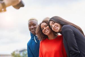 multi ethnisch freunde draussen. vielfältig Gruppe Menschen afro amerikanisch asiatisch Ausgaben Zeit zusammen foto