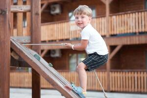 Junge abspielen Spielplatz Kind Klettern Seil draussen Kinder gesund Sommer- Aktivität foto