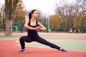 glücklich Mädchen tun Fitness Übungen draussen auf Spielplatz. gesund Lebensstil. Morgen trainieren positiv Emotion lächelnd sportlich Menschen foto