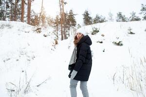 schönes Winterporträt der jungen Frau in der schneebedeckten Winterlandschaft foto