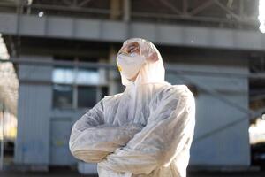 covid-19 Coronavirus Arzt Stehen Krankenhaus Parkplatz gekleidet Weiß schützend Overall Hazmat Anzug. foto