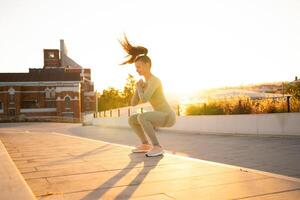 sportlich Frau tun Springen Kniebeugen Übungen auf Treppe im Park. Körpergewicht Ausbildung auf Sonnenuntergang. foto