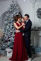 Mama Papa und Tochter gekleidet im ein stilvoll passen und elegant rot Abend Kleid beim ein weltlich Party im Ehre von das Neu Jahr foto