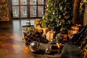 festlich Weihnachten Exposition beim heim. dekoriert Weihnachten Baum mit viele von Geschenke von golden, braun und schwarz Farben und groß Silber Disko Bälle foto