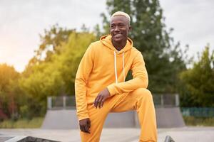 afrikanisch amerikanisch lächelte Mann im Gelb Kapuzenpullover draussen foto