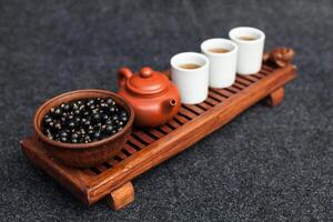 traditionell Chinesisch Tee Zeremonie mit schwarz Johannisbeere, Obst Tee und gesund Lebensmittel. Foto ohne Personen. Sommer- natürlich Vitamine und Beeren