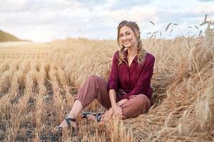 Frau Farmer Sitzung Ackerland lächelnd weiblich Agronom Spezialist Landwirtschaft Landwirtschaft glücklich positiv kaukasisch Arbeiter landwirtschaftlich Feld foto