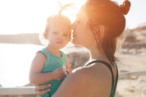 Mutter umarmen mit ihr wenig Tochter draussen im Natur auf sonnig Tag positiv Mensch Emotionen, Gefühle, Emotionen. foto