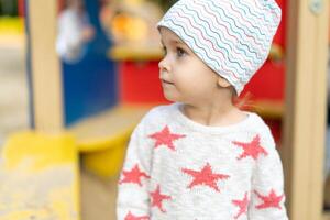 wenig kaukasisch Mädchen Nahansicht Porträt gekleidet im ein Hut und ein Sweatshirt mit Sterne foto