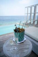 ein Champagner Flasche auf Eimer gefüllt mit Eis auf mit tropisch Ozean Hintergrund. foto