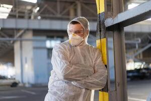 covid-19 Coronavirus Arzt Stehen Krankenhaus Parkplatz gekleidet Weiß schützend Overall Hazmat Anzug. foto