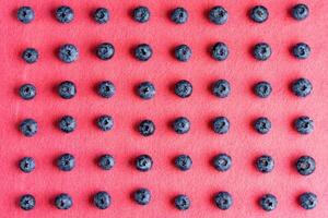 bunt Obst Muster von Blaubeeren auf Rosa Hintergrund. oben Sicht. foto