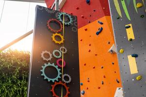 Innen- Bouldern und Klettern Mauer zum Ausbildung beim modern Fitnessstudio. Getriebe und Spielzeug Klettern Mauer zum Kinder foto