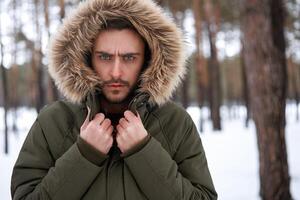 attraktiv bärtig Mann Stehen draußen im Winter Jahreszeit Wald. foto