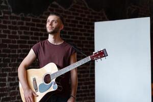 Mann mit akustisch Gitarre Stehen in der Nähe von Whiteboard Musik- Schule Konzept foto